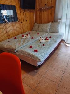 a bed with flowers on it in a room at Tündérrózsa Horgászkuckó in Gyomaendrőd