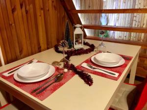 einen Tisch mit zwei weißen Platten und einer roten Serviette in der Unterkunft Tündérrózsa Horgászkuckó in Gyomaendrőd