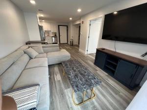 a living room with a couch and a large flat screen tv at The Chic Suite - 1BR with Luxe Amenities in Paterson