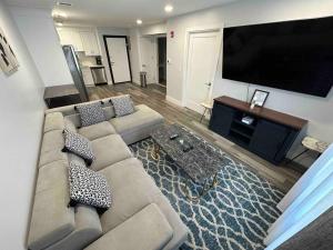 a living room with a couch and a flat screen tv at The Chic Suite - 1BR with Luxe Amenities in Paterson