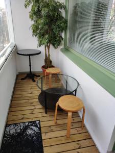 a room with a table and stool and a potted tree at M Apartments Tesomankuja in Tampere