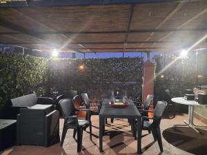 a patio with a table and chairs and a hedge at Casa vacanze Leto in Letojanni