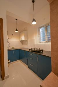 a kitchen with blue cabinets and a blue counter top at HomeSlice Whitefield - 1BHK/ 2BHK Apartment/ Studio Room in Bangalore