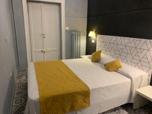 a bedroom with a large white bed with yellow pillows at Villa Giovanna Citylife Milano in Milan