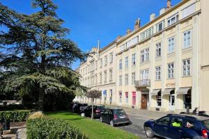 een straat met auto's geparkeerd voor een gebouw bij Széchenyi Apartment Sopron in Sopron