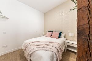 BNBHolder Hunky ATOCHA في مدريد: غرفة نوم بيضاء مع سرير كبير مع وسائد وردية