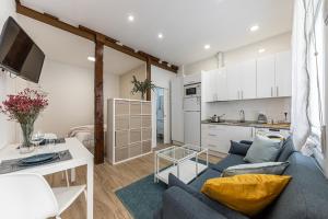BNBHolder Hunky ATOCHA في مدريد: غرفة معيشة مع أريكة زرقاء ومطبخ