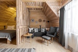una camera con letto, divano e sedia di Gremi Hotel a Dragobrat