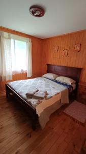 1 dormitorio con 1 cama grande en una habitación en Complejo De Cabañas Rukafill, en San José de la Mariquina