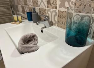 lavamanos con jarrón de cristal y toalla en CASA ARBOL DE VIDA, en Altea
