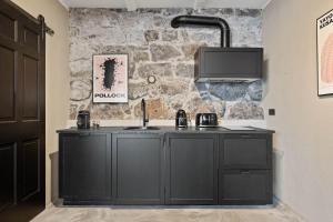 uma cozinha com um armário preto e uma parede de pedra em Historic Villa in downtown Reykjavik em Reykjavík