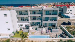 an aerial view of a large white building with a swimming pool at Apartments Pool Villa Maria, Novalja in Novalja