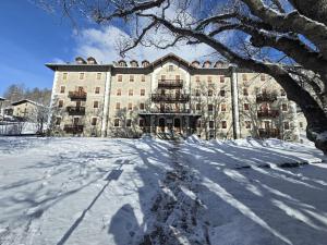 a large building with snow in front of it at Appartamenti e camere del Re e della Regina - Grand Hotel Ceresole Reale in Ceresole Reale