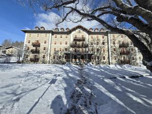 a large building with snow in front of it at Appartamento del Re e della Regina in Ceresole Reale