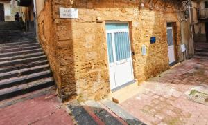 a stone building with a white door and stairs at Historic Center Apartment in Agrigento