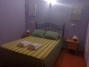 une chambre avec un lit avec deux serviettes dessus dans l'établissement CASA RURAL LA SERROTA, à San Martín de la Vega del Alberche