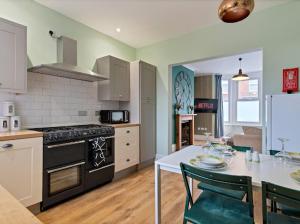 a kitchen with a table and a stove top oven at 5* Fully furnished 5 bedroom service accommodation/holiday home - Sleeps up to 10 guests in Spinney Hill