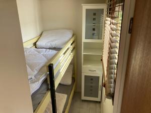 Tiny house CC4 - it Soal Workum في فوركوم: غرفة صغيرة مع سريرين بطابقين وخزانة