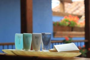 サン・クリストバル・デ・ラス・カサスにあるDocecuartos Hotelのコーヒーカップ3杯とパン皿付きトレイ