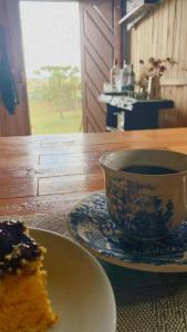 eine Tasse Kaffee und ein Stück Kuchen auf dem Tisch in der Unterkunft Casa de Campo Gralha Azul in Bom Jardim da Serra