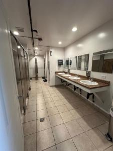 a large bathroom with three sinks and mirrors at House of Trestles in San Clemente