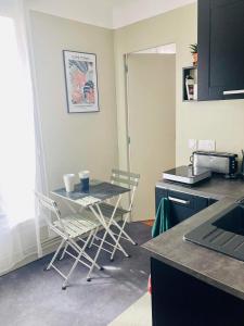 - une cuisine avec une table et des chaises dans la chambre dans l'établissement Belle chambre avec cuisine et salle de bain à la porte de Paris, à Ivry-sur-Seine