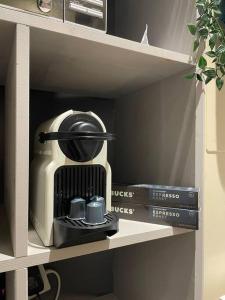 a coffee maker sitting on a shelf with books at Hoxton Live/Work Studio in London