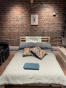 a bed in a room with a brick wall at Hoxton Live/Work Studio in London