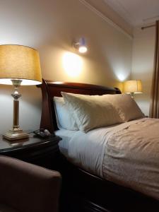 a bedroom with a bed with two lamps and a couch at Woodhaven Manor h91rc9d in Galway