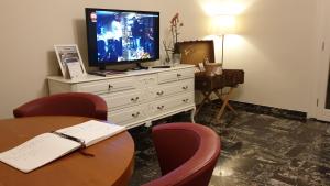 a hotel room with a tv and a table and chairs at A Casa di Luca in Faenza +9 photos