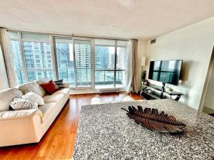 - un salon avec un canapé et une télévision dans l'établissement Lake View Apartment w/Parking!, à Toronto