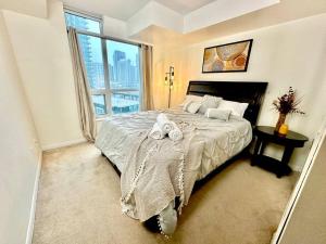a bedroom with a large bed and a large window at Lake View Apartment w/Parking! in Toronto