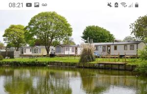 a row of houses next to a body of water at 6 Berth Caravan on Lakeside Holiday Park in Burnham on Sea