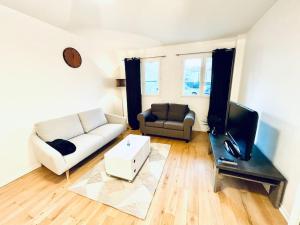 a living room with a couch and a tv at Nice 1 bedroom in Chantilly in Chantilly