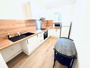 a kitchen with white cabinets and a wooden floor at Nice 1 bedroom in Chantilly in Chantilly