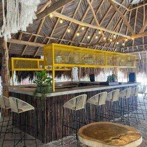 - un bar avec un bouquet de chaises et une table dans l'établissement Island-style lodging & beach club, à Tierra Bomba