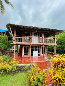 une maison avec une terrasse couverte et un balcon dans l'établissement Island-style lodging & beach club, à Tierra Bomba