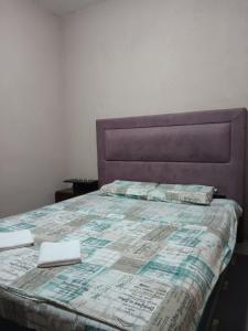a bed with a quilt and two towels on it at Bandici house in Podgorica