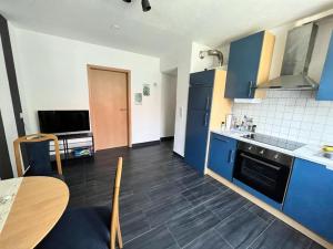 a kitchen with blue cabinets and a wooden table at Jennis Bi-Bi 2 bedrooms Apartment in Bietigheim-Bissingen