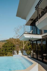a house with a swimming pool next to a building at Vida Palace in Jacó
