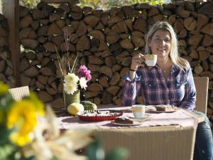 een vrouw aan een tafel met een kopje koffie bij Vakantiewoning in Zwarte Woud in Eichstetten