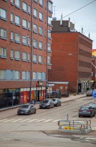 Ulica z samochodami zaparkowanymi przed ceglanym budynkiem w obiekcie 2-Bedroom Apartment in Heart of City Center w mieście Turku