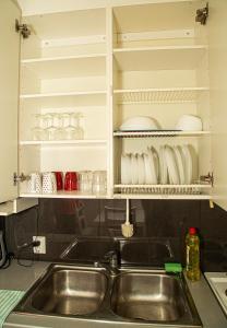 a sink in a kitchen with white cabinets at 2-Bedroom Apartment in Heart of City Center in Turku