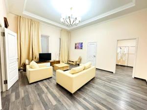 een woonkamer met 2 banken en een televisie bij Merdan Hotel in Zaozërnyy