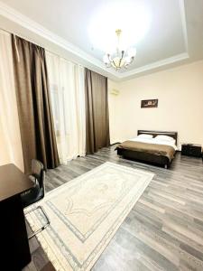 ein Schlafzimmer mit einem Bett und einem Teppich auf dem Boden in der Unterkunft Merdan Hotel in Zaozërnyy