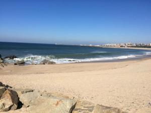 - une plage avec des rochers dans le sable et l'océan dans l'établissement Cosy House in Porto Marina, à Vila Nova de Gaia 2 autres photos