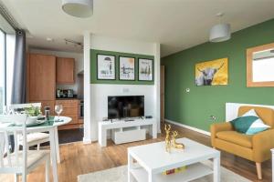 a living room with green walls and a dining room at Luxury Milton Keynes Apartment at The Prevé in Milton Keynes