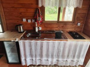 a kitchen with a sink and a counter top at Chalé Eco Camping Kazeando Pelo Mundo in Urupema