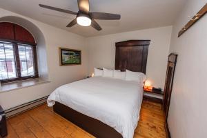 a bedroom with a bed with a ceiling fan at Orange Bistro in Baie-Saint-Paul