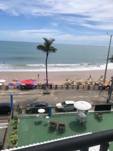 uma vista para uma praia com mesas e guarda-sóis em Ponta Negra Suites & Apart em Natal